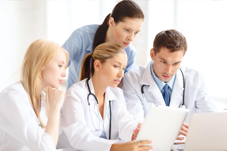 Négy egészségügyi dolgozó nézi az egészségügyi szoftvert